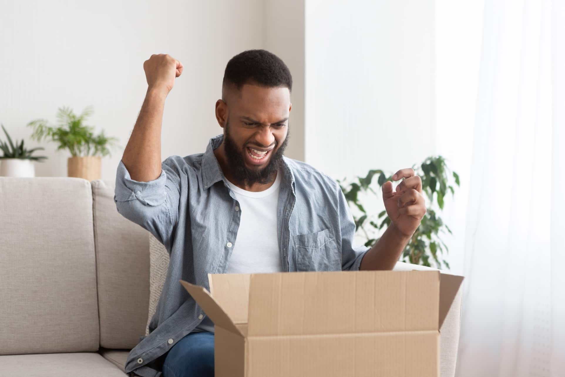 Male client unpack box at home, feel excited with good quality order